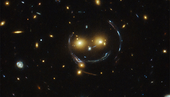 A deep space image showing galaxies that seem to form a smiling face