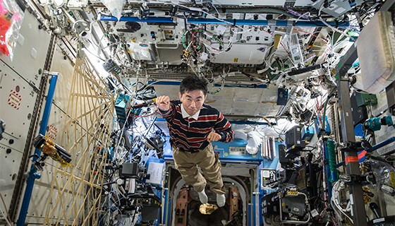 Astronaut Kimiya Yui poses like a superhero while flying through the space station