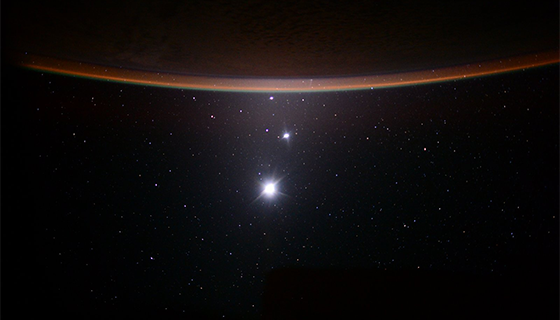 Earth's moon, Venus and Jupiter line up below the horizon of Earth in this photo taken from the space station