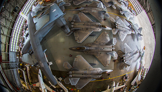 Wide-angle lens view of a hangar filled with aircraft