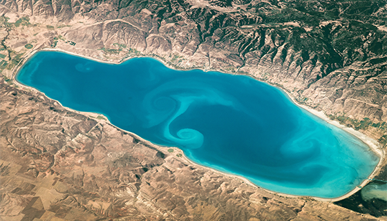 A bright blue lake with aqua-colored swirls in the center