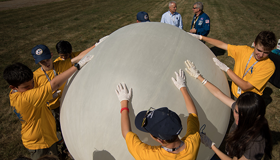 Boy Scouts outdoors preparing a weather balloon for flight