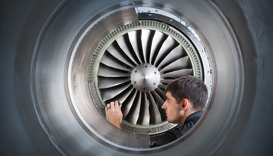 NASA researcher Rick Bozak inspects the fan blades of an aircraft engine rotor