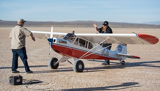 Two men prepare a large remote-controlled airplane for flight