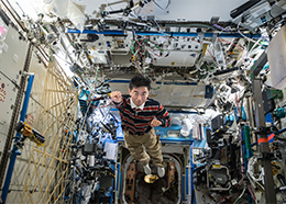 Astronaut Kimiya Yui poses like a superhero while flying through the space station