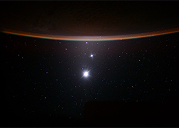 Earth's moon, Venus and Jupiter line up below the horizon of Earth in this photo taken from the space station