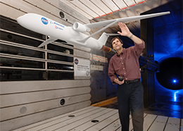 A man prepares an airplane model for testing in a wind tunnel