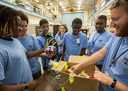 Students inspecting objects inside a cardboard box