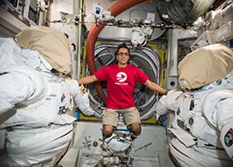 Astronaut Joe Acaba floats between two spacesuits on the space station
