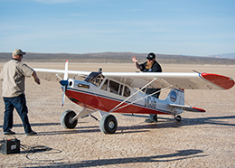 Two men prepare a large remote-controlled airplane for flight