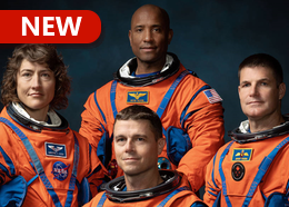 NASA astronauts Reid Wiseman, Christina Koch, and Victor Glover pose with Canadian astronaut Jeremy Hansen, all wearing orange spacesuits