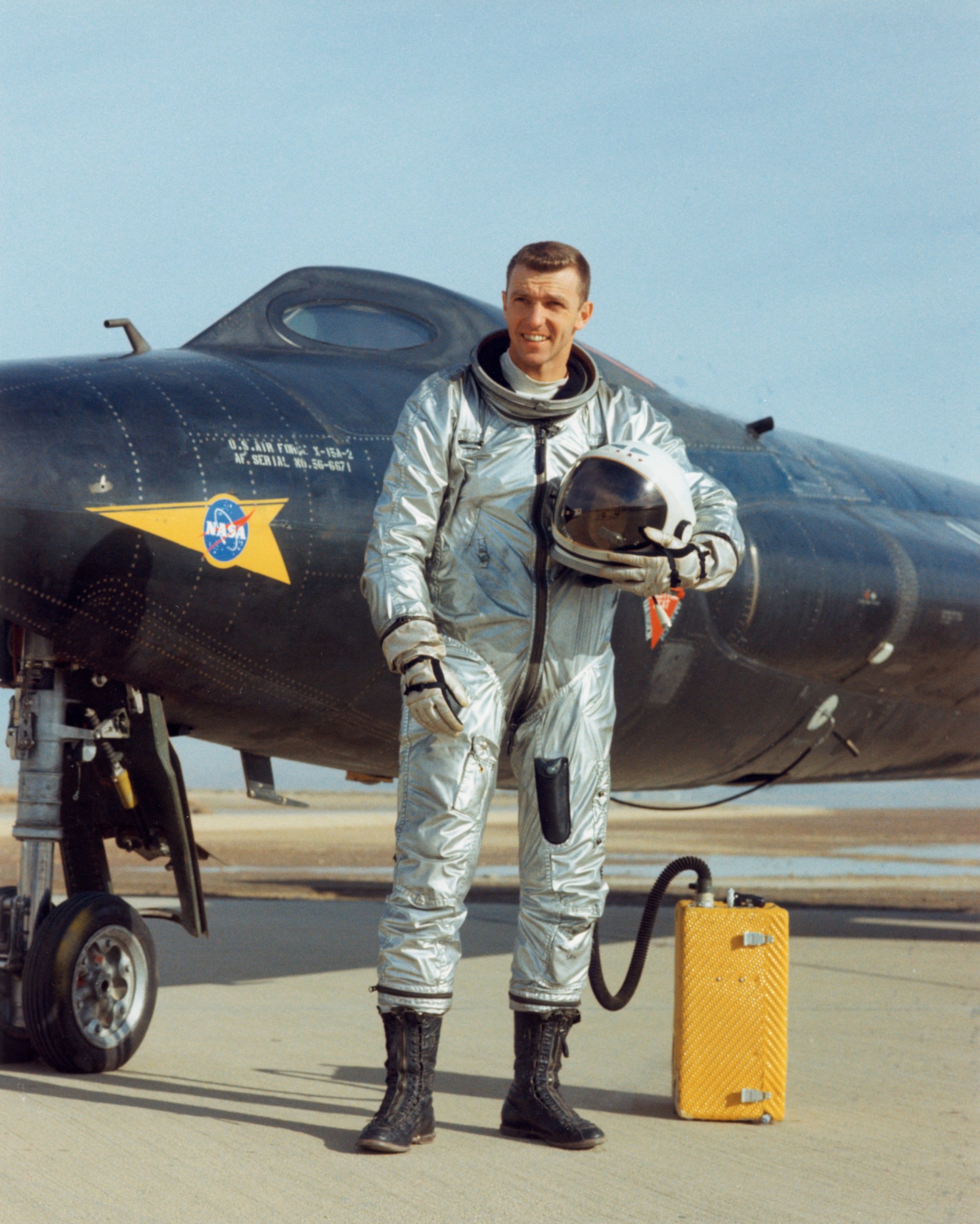 Joe Engle holding his helmet standing in front of the X-15 aircraft.