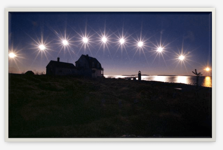 The sun, nearing winter solstice, travels low across the sky in a multiple-exposure picture made in Maine in 2002.