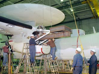 Technicians at NASA Dryden's flight loads lab install a fixture inside an engine nacelle in preparation for major structural loads tests on an E-2C Hawkeye.
