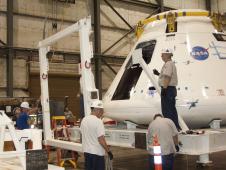 Technicians at NASA Dryden install the goalpost fixture to the Orion crew module integration stand during conversion of the stand into a transportation fixture for airlift of the module to the White Sands Missile Range in New Mexico.