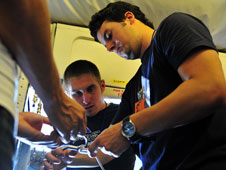 Student Airborne Research Program environmental science students Eric Kauffman from Stephen F. Austin State University (left) and Clayton Elder from Oklahoma State University (right) bend tubing to complete the installation of the Whole Air Sampler onboard NASA's DC-8 airborne science laboratory.