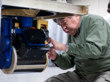 NASA Goddard engineer Zhaonan Zhang adjusts the Conical Scanning Millimeter-wave Imaging Radiometer, or CoSMIR, scan head prior to installation in NASA's DC-8 flying science laboratory.