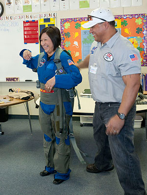 School employee Nancy Pena shows off a high-G flight suit used by NASA pilots.