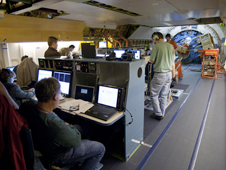 Astronomers and mission operations staff monitor data at their consoles during a science flight aboard the SOFIA flying observatory.