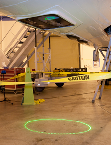 The Airborne Topographic Mapper projects a circle of laser light through a custom optically precise window mounted in the forward belly of NASA's DC-8 flying science laboratory onto the hangar floor during instrument checkout for the 2012 IceBridge Antarctic campaign.