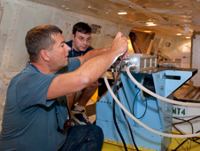 IceBridge mission scientists Jim Yungel and Matt Linkswiler make final adjustments during installation of the Airborne Topographic Mapper in the lower fuselage of NASA's DC-8 flying laboratory prior to departing on the 2012 Antarctic IceBridge mission