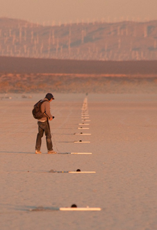 A FaINT project researcher adjusts one of the microphones in a linear array nearly 1 1/2 miles long laid out by the project team to record and measure sonic booms.
