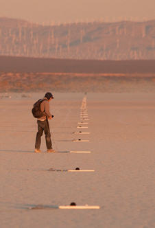 A FaINT project researcher adjusts one of the microphones in a linear array nearly 1 1/2 miles long laid out by the project team to record and measure sonic booms.