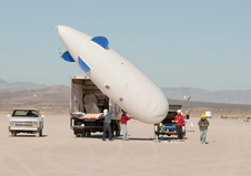 Cessna researchers prepare to launch a blimp that carries several microphones used to record sonic booms for the FaINT project. The tethered blimp flies at an altitude of about 3,000 feet above ground to collect sonic boom data at that altitude.