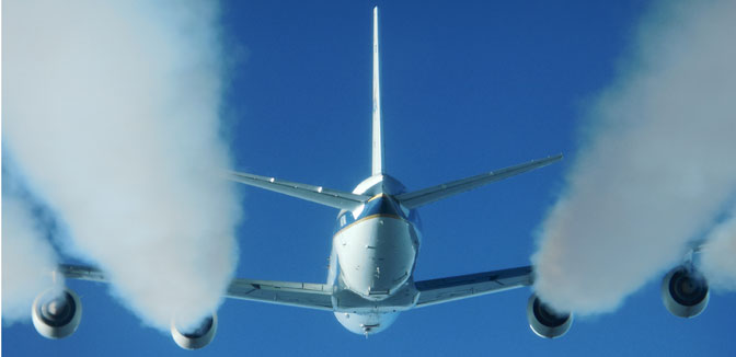 Puffy white exhaust contrails stream from the engines of NASA's DC-8 flying laboratory in this photo taken from an HU-25 Falcon flying in trail about 300 feet behind the DC-8.