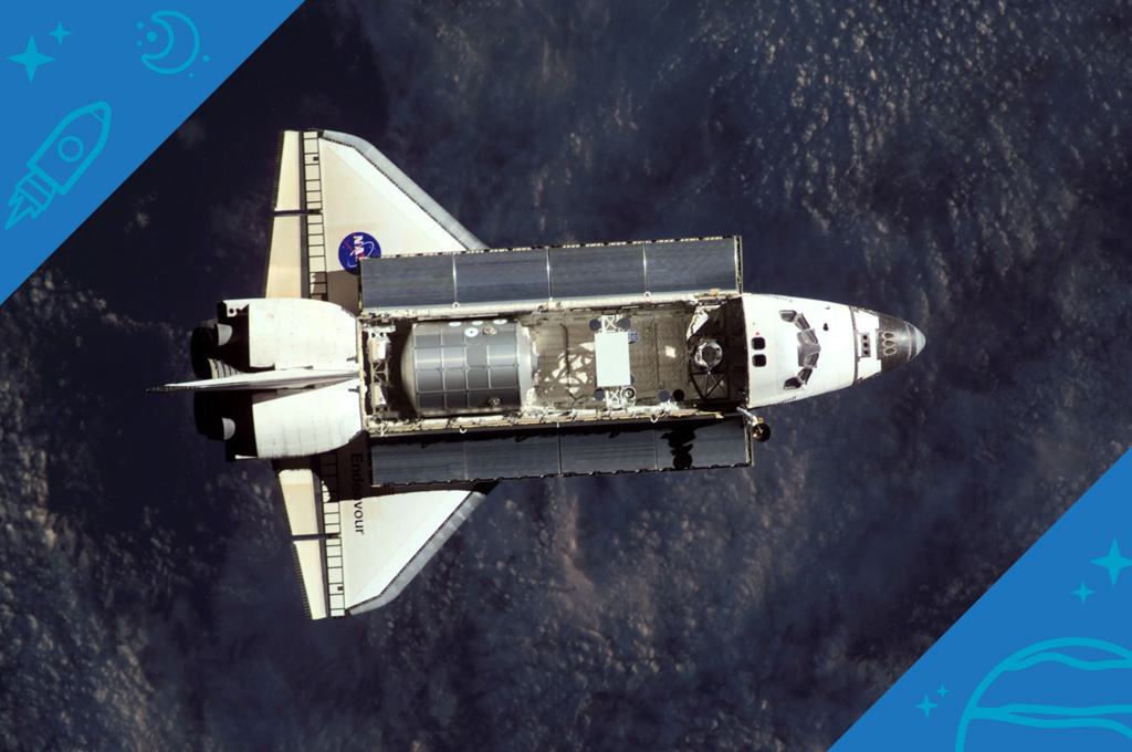The Space Shuttle Endeavour, controlled by the flight crew of STS-108, is backdropped over a dark mass of clouds as it approaches the International Space Station (ISS).