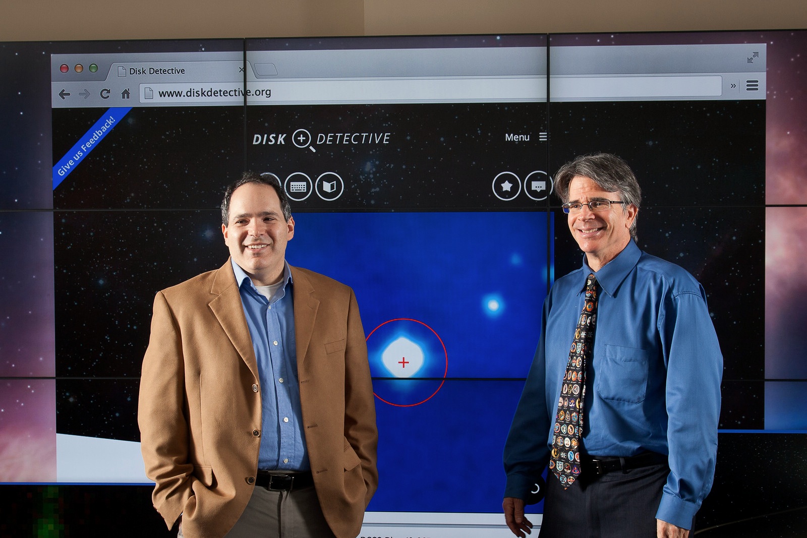 Marc Kuchner and Jim Garvin stand in front of a computer screen showing the DiskDetective.org website.