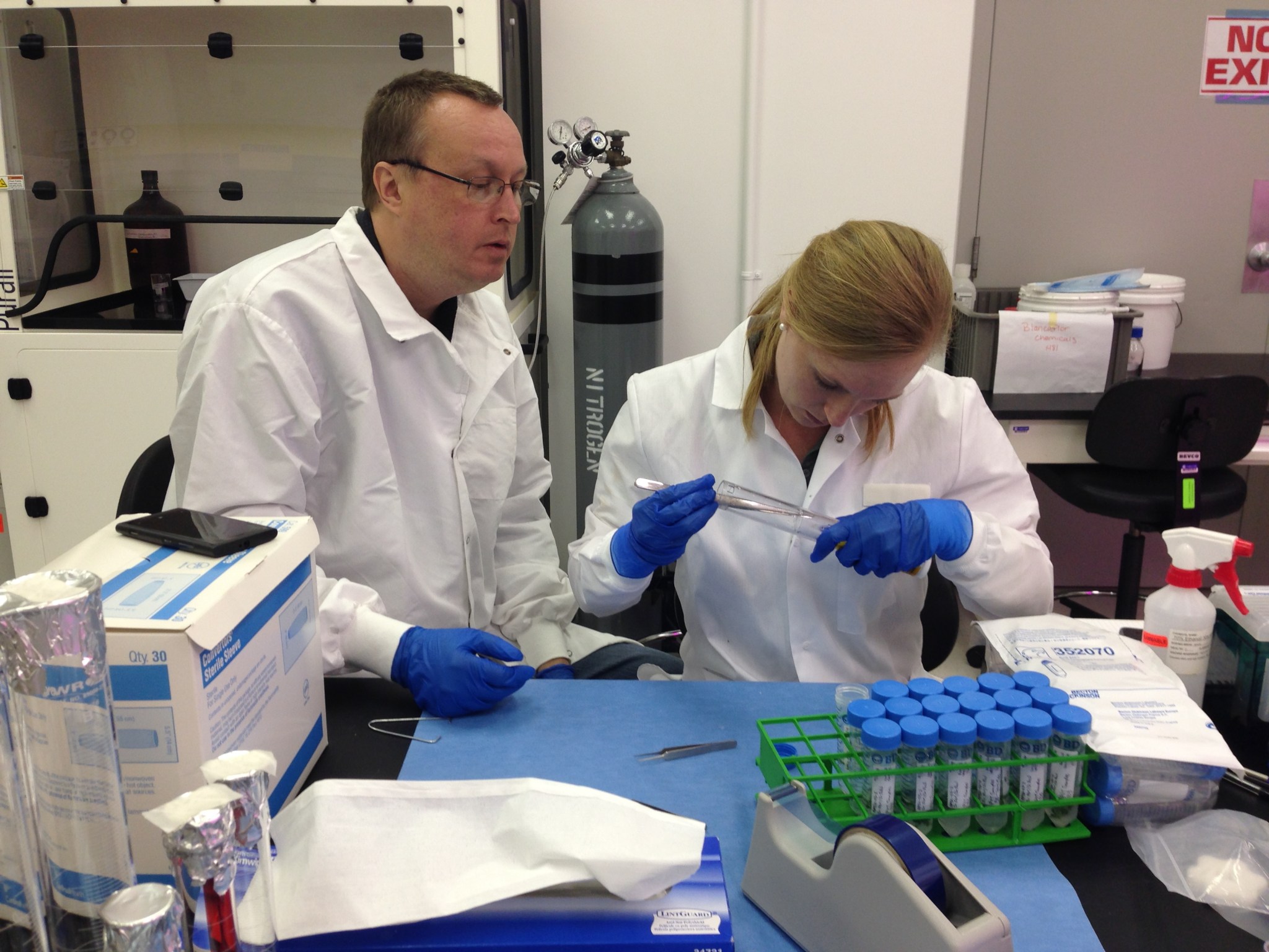 Shawn Stephens, left, APEX project engineer, and Allison Mjoen, paylod integration engineer, prepare samples of one of the APEX-03 experiments inside a laboratory at the Space Station Processing Facility at NASA’s Kennedy Space Center.