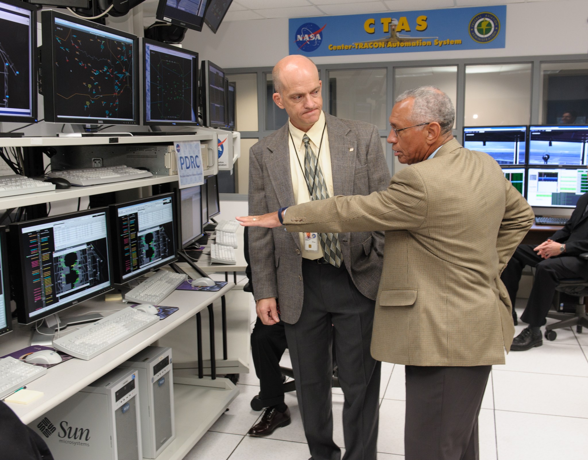 NASA Administrator Charlie Bolden talking to a man and pointing to a monitor.