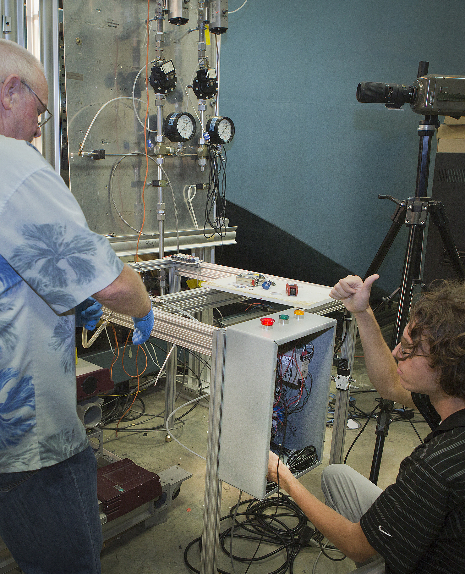 Researchers Ron Penner (l) and John Gardner prep the device used to transport fruit flies into the wind tunnel.