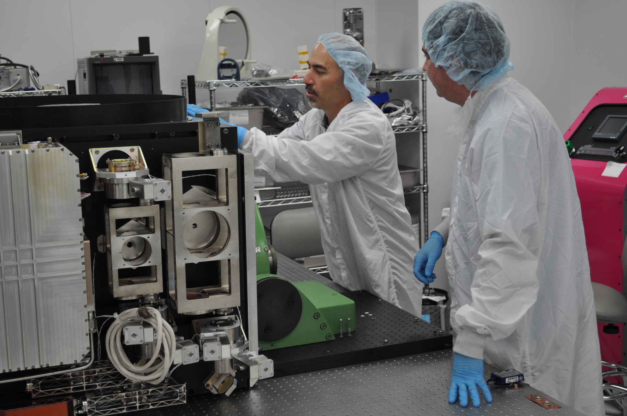 technicians in bunny suits test fitting components