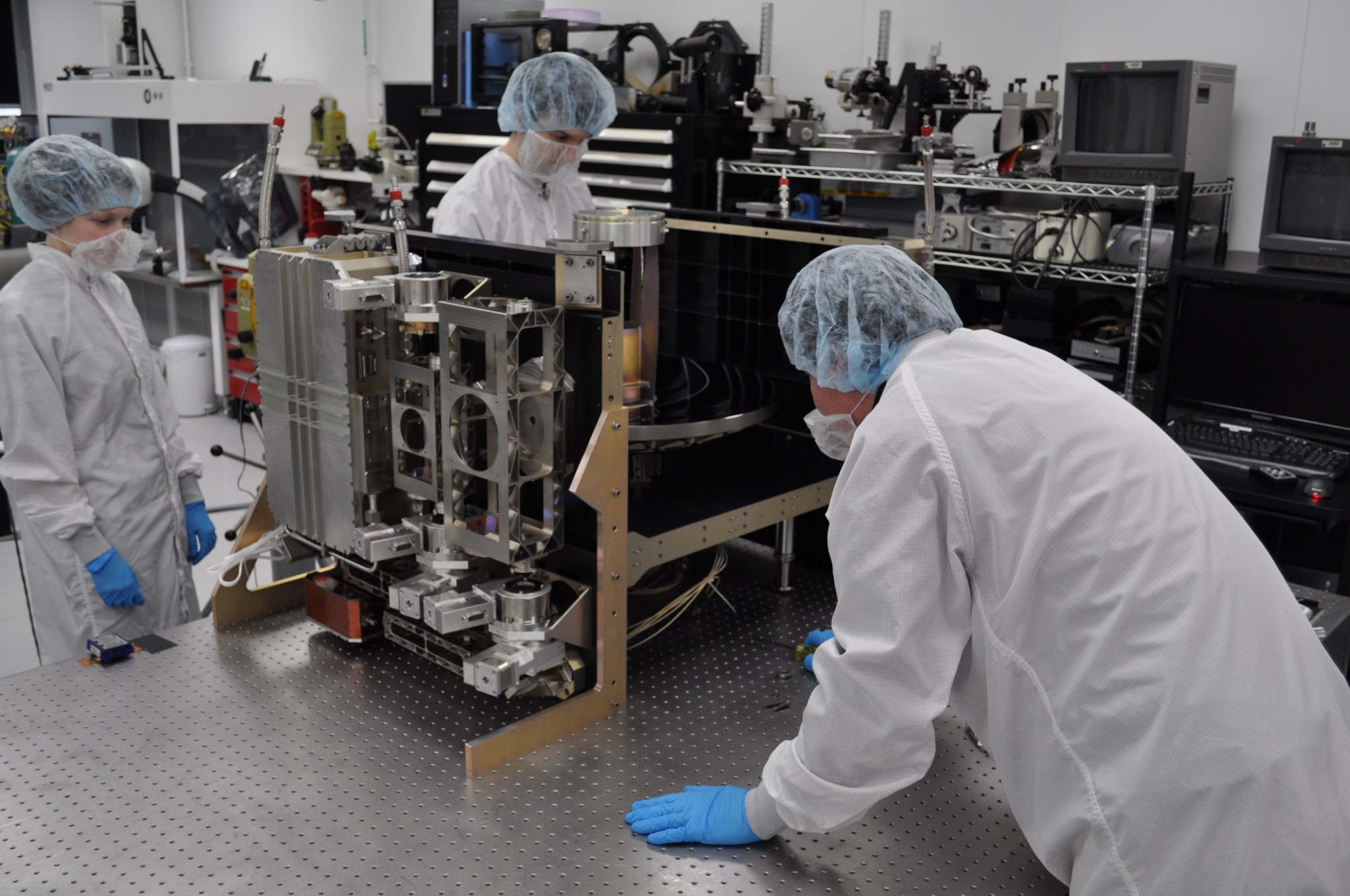 technicians in bunny suits working on transceiver alignment