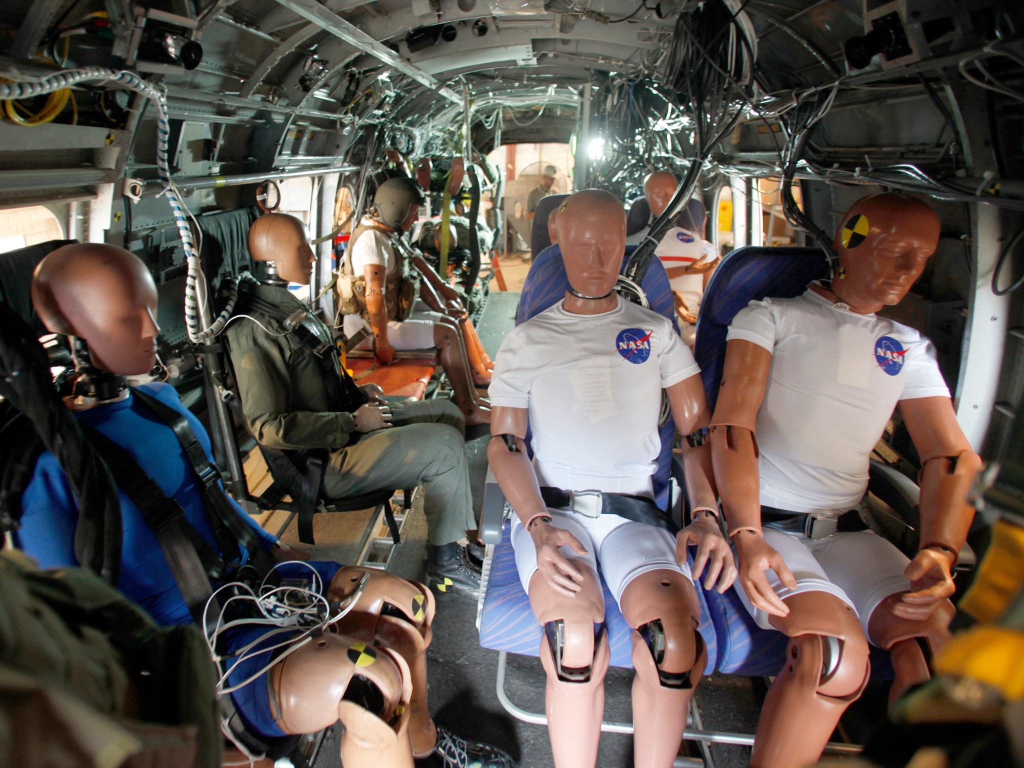Crash test dummies in seats within the helicopter that will go through a crash test.