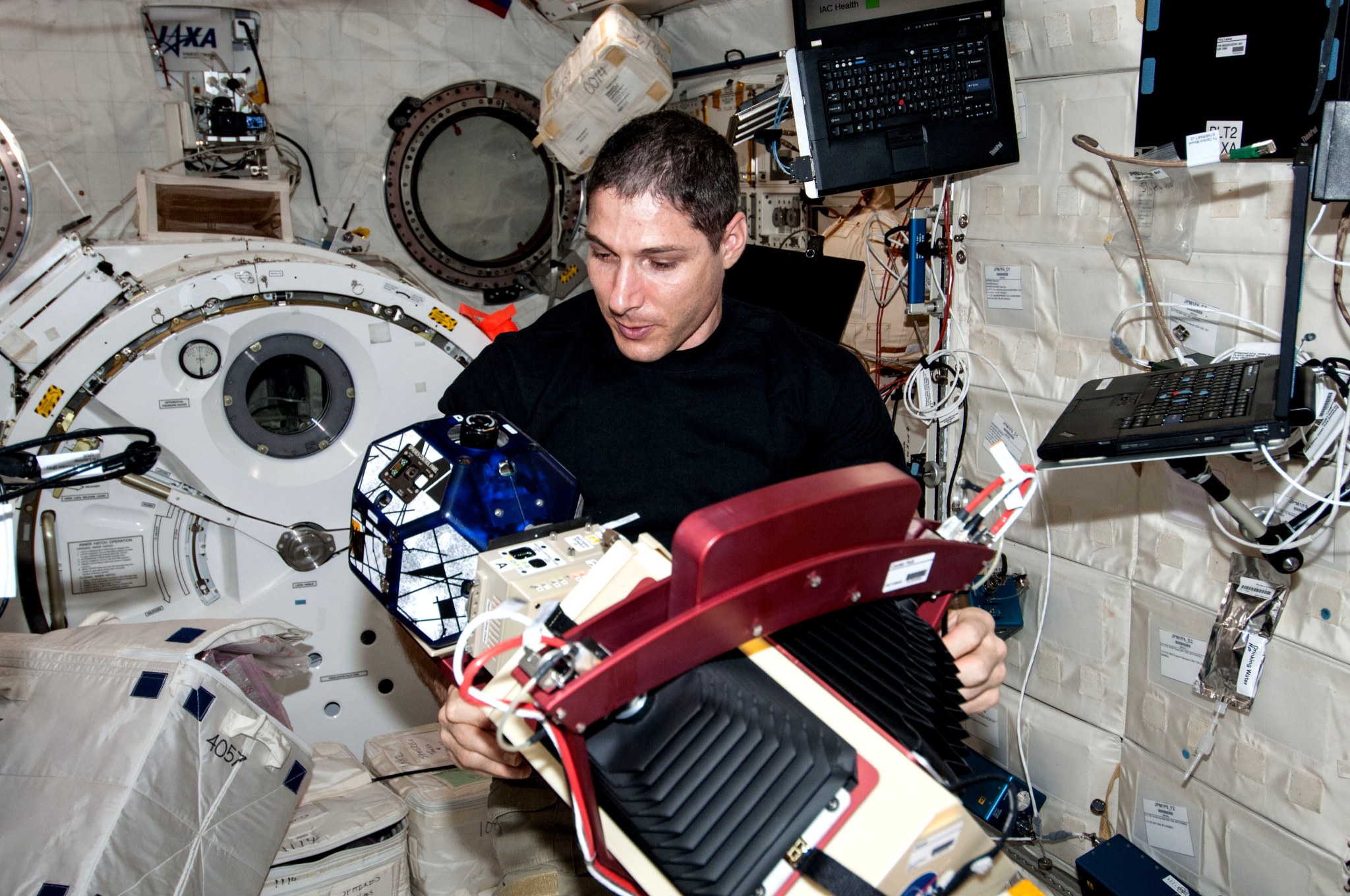 Aboard the International Space Station on Jan. 22, 2014, Expedition 38 flight engineer Mike Hopkins works with the Slosh experiment.