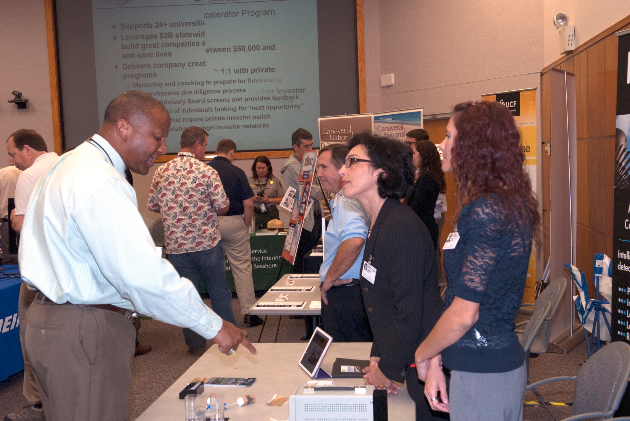 Vendors discuss innovative applications with Kelvin Manning, associate director of NASA's Kennedy Space Center, during the Innovation Expo.