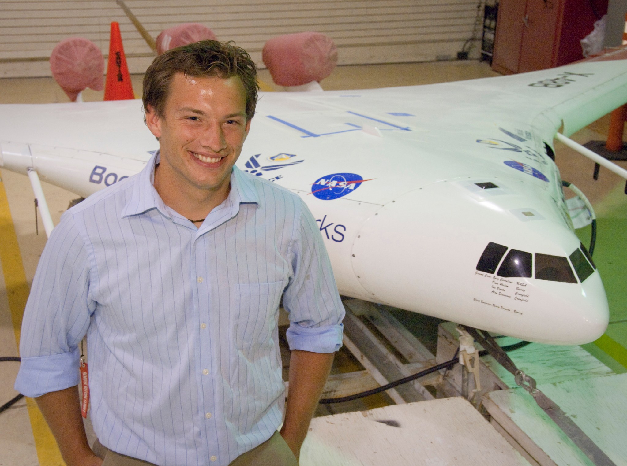 An intern standing near the X-48B.