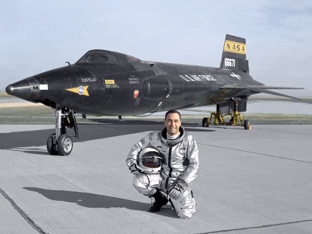 Air Force pilot William "Pete" Knight, kneeling in front of the X-15.