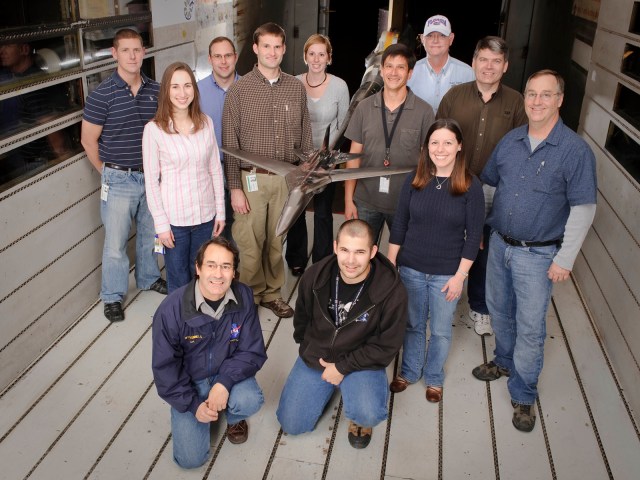 Facility Aerodynamics Validation and Operational Research model in wind tunnel with Test Crew standing nearby
