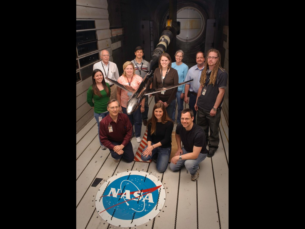 model of generic transport airplane in wind tunnel with Model Test Crew standing nearby