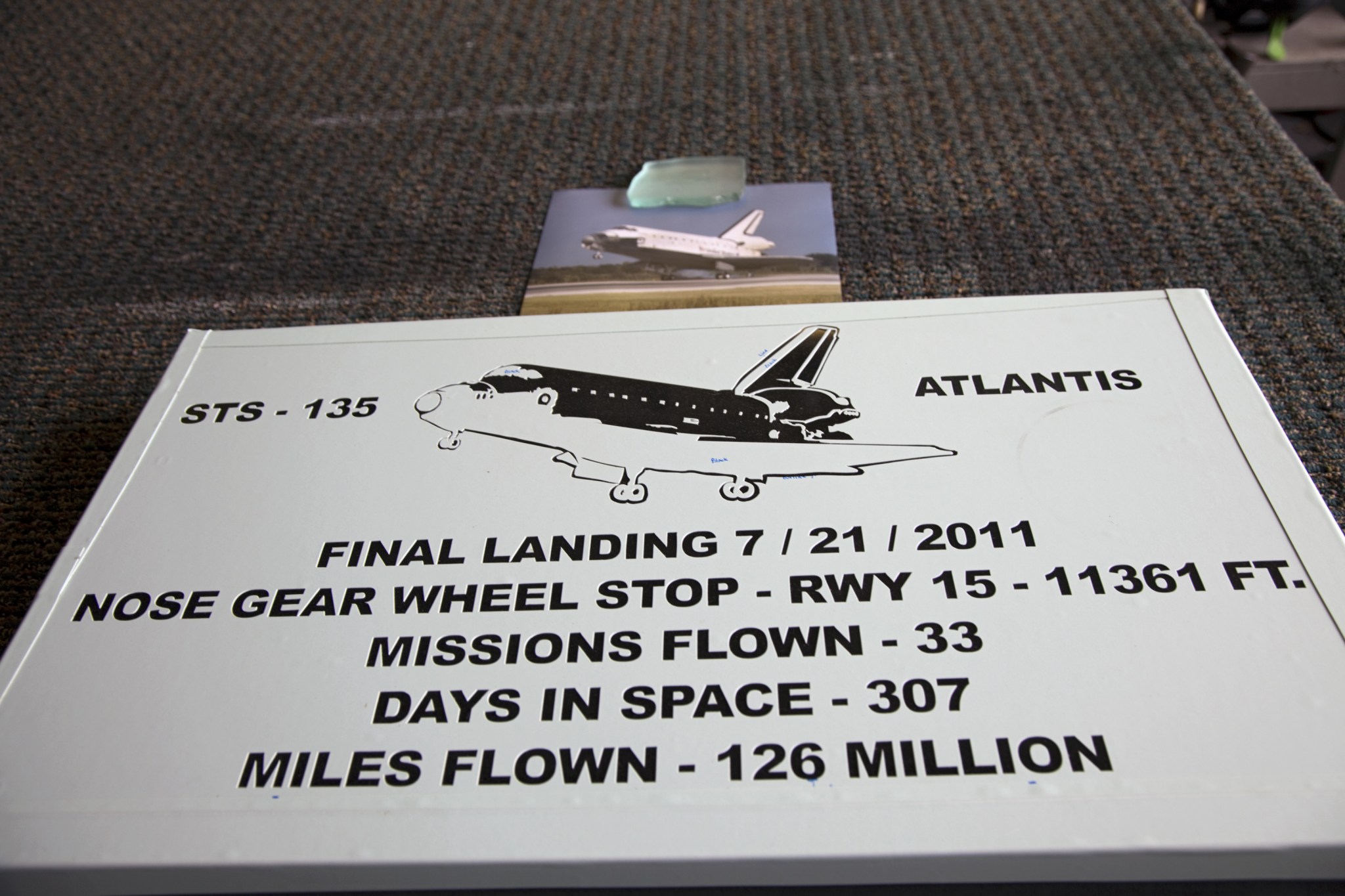 Engraved template with shuttle silhouette and photo of shuttle above