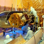 Workers in the Multi-Purpose Processing Facility look over the Solar Radiation and Climate Experiment (SORCE) satellite.
