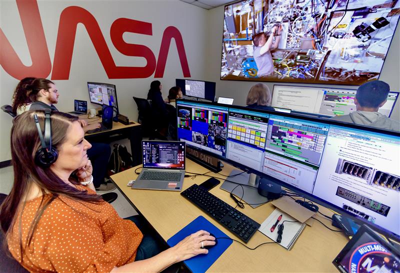 people sitting at desks with computer monitors