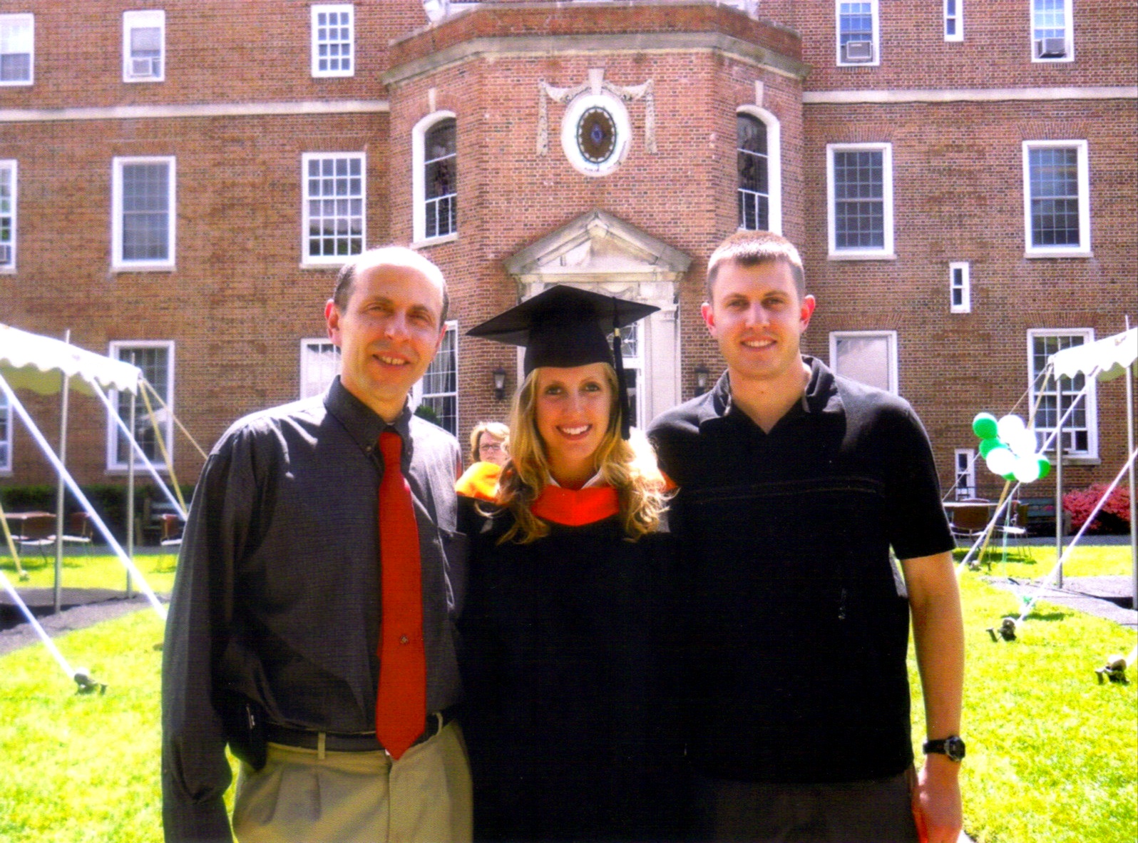 A photo of Annie Caraccio with her father and brother following her college graduation.
