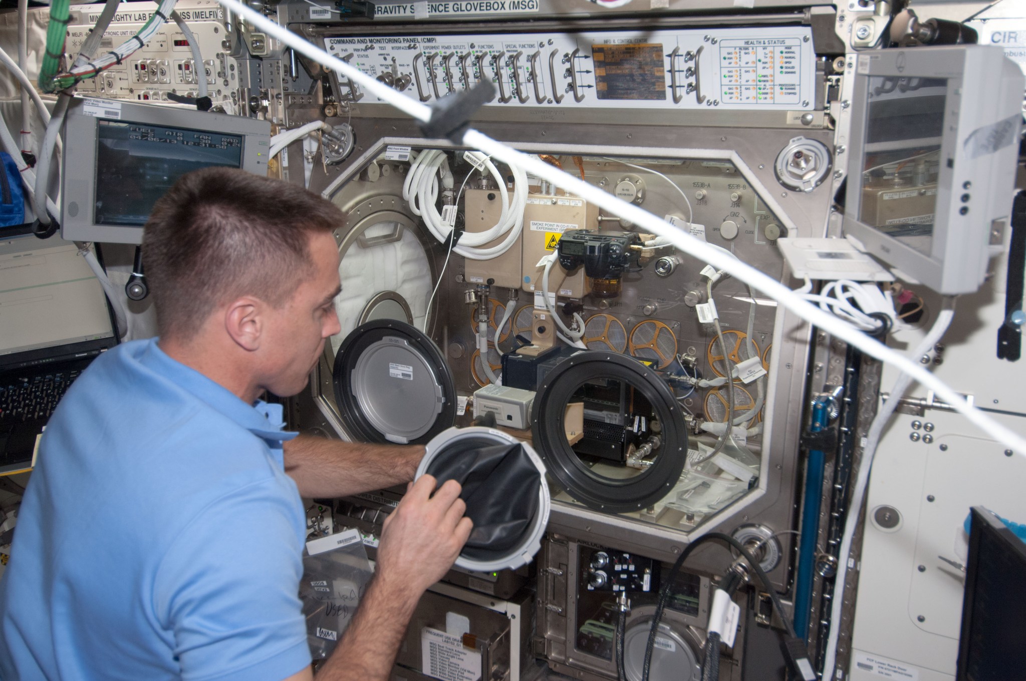 Astronaut Chris Cassidy installing the right glove on the Microgravity Science Glovebox just before starting a BASS investigatio