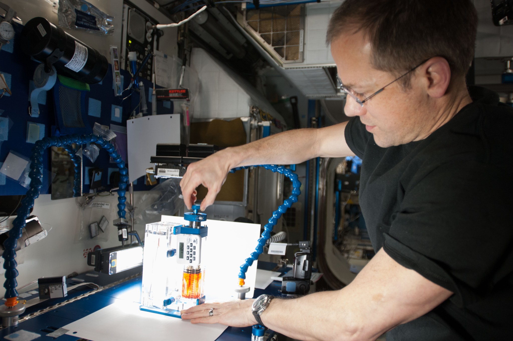NASA astronaut Tom Marshburn uses a Capillary Flow Experiment (CFE)-2 vessel to perform several interior corner flow tests. CFE 