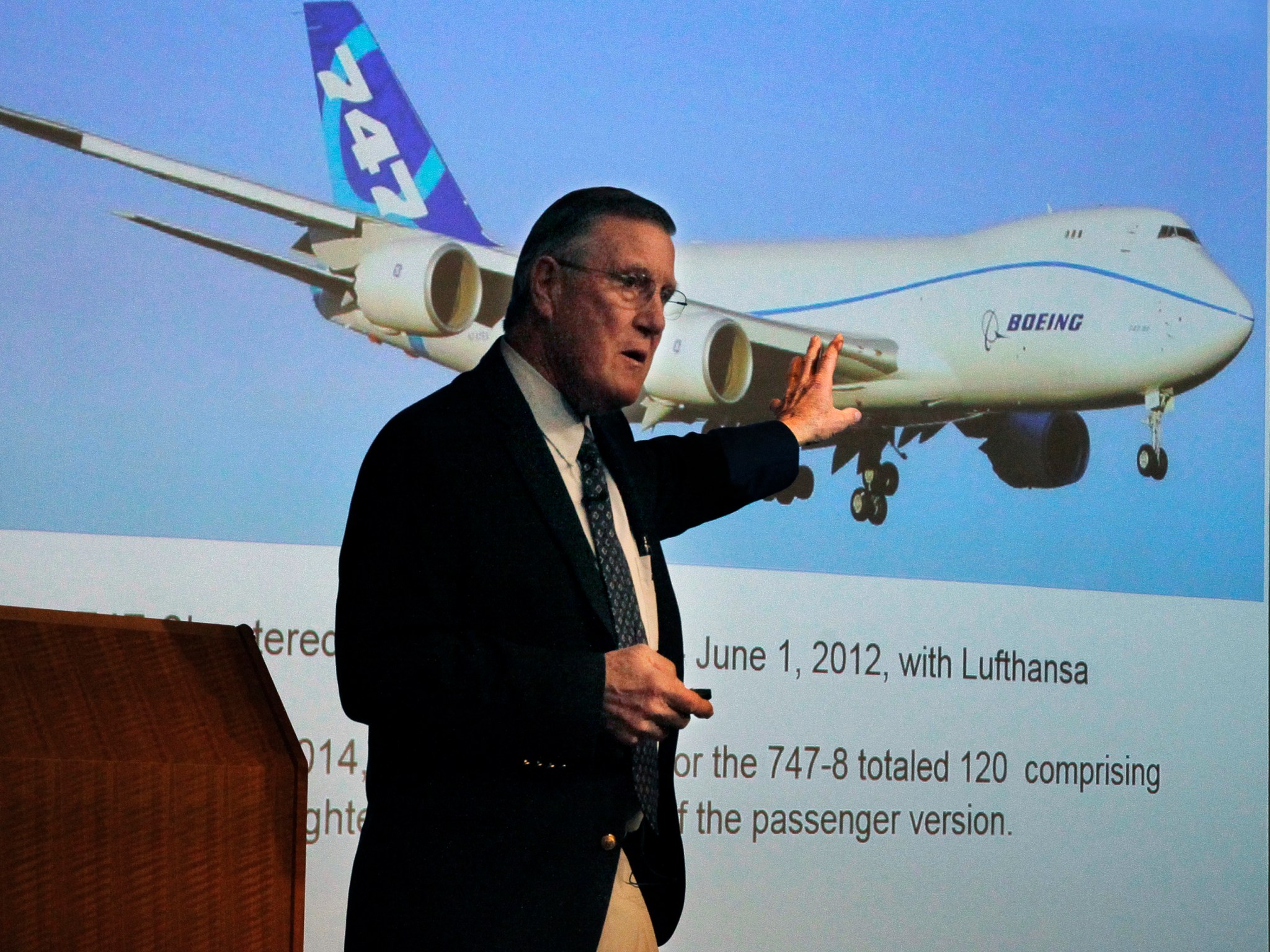 A man pointing to a picture of a Boeing aircraft.